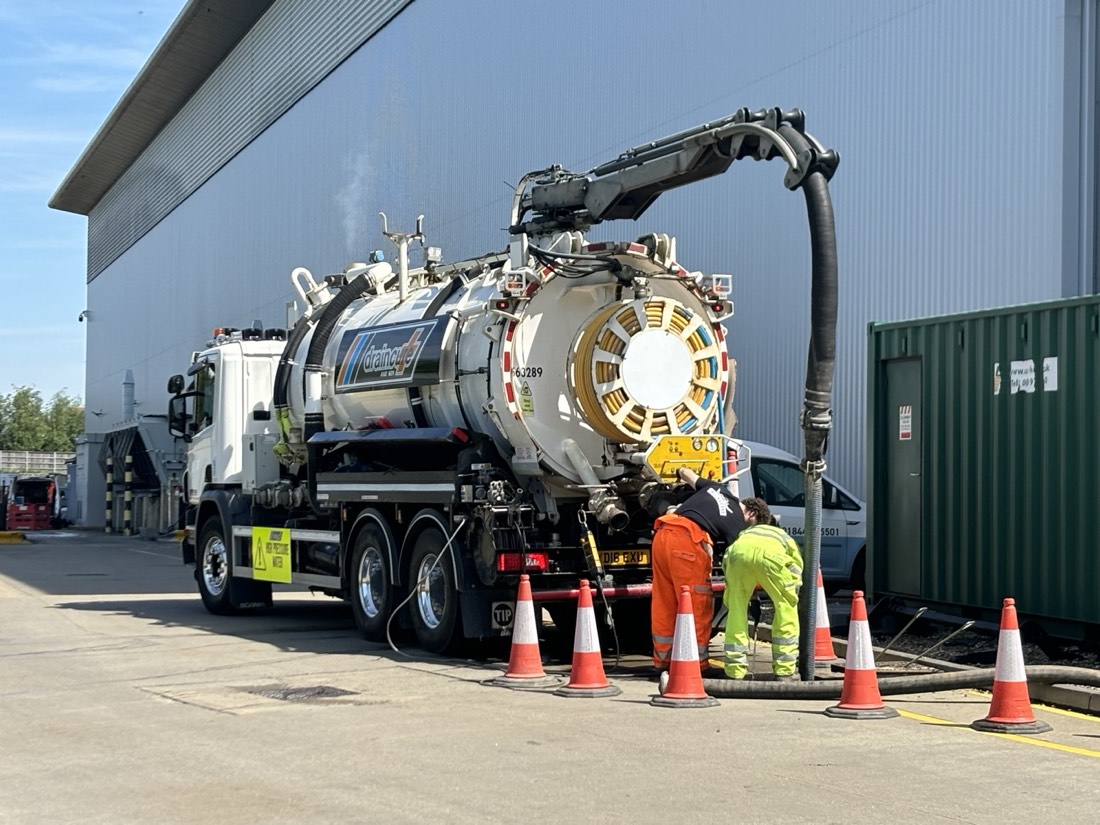 Engineers carrying out deep sewer maintenance with a suction tanker