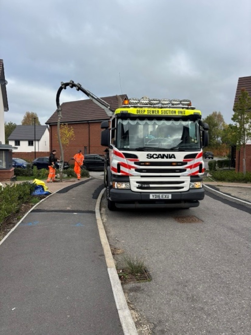 Crew operating a sewer pump unit on site