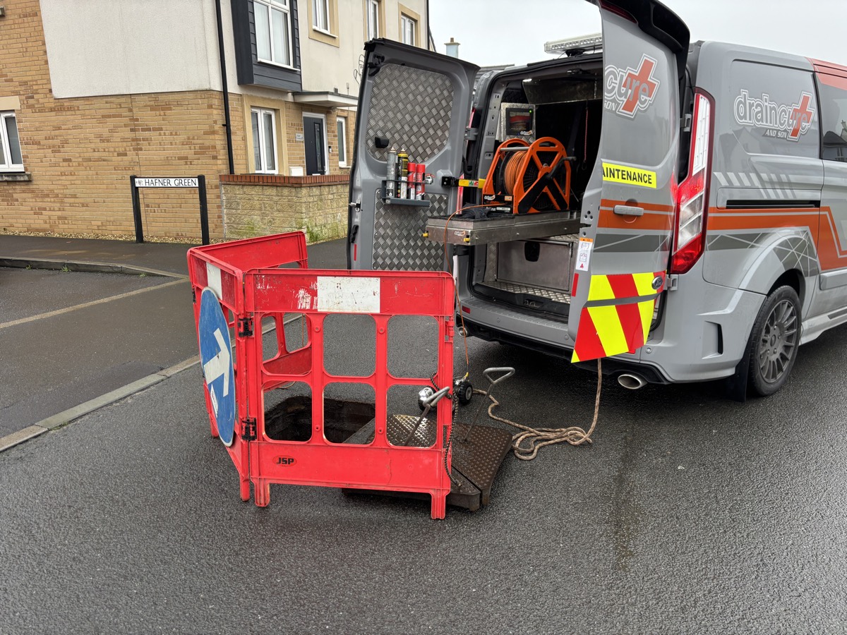 Draincure & Son survey van kitted out with cable reel and safety barrier at a job site